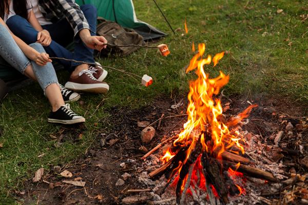 close up young couple enjoying bonfire - Организация трапезы в походе: хранение продуктов, походная кухня, утварь, меню